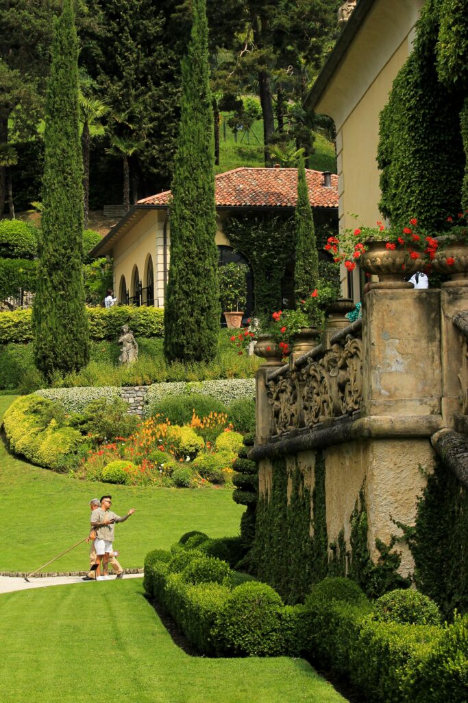Beautiful garden at a villa in Lenno, Italy with lush greenery and classic architecture.